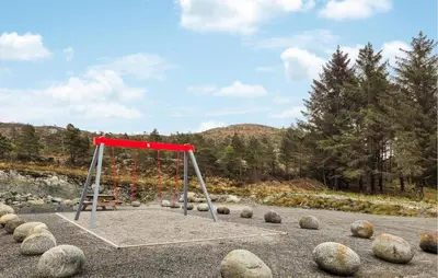 a swing set in a park with rocks around it at Awesome Home In Sveio in Sveio
