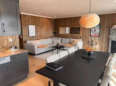 a kitchen and living room with a couch and a table at Geilo Kikut - Ski-in Ski-out in Geilo