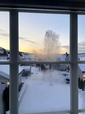 a view from a window of a snow covered yard at Koselig hus med stor og solrik hage in Lillehammer