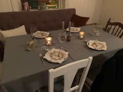 a table with plates and glasses and candles on it at Koselig hus med stor og solrik hage in Lillehammer