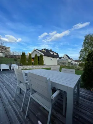 a white table and two chairs on a deck at Koselig hus med stor og solrik hage in Lillehammer