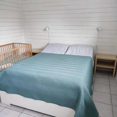 a bed with a blue comforter in a room at Lillehammer, Gjøvik pâ 2836 Biri apartments in Biri