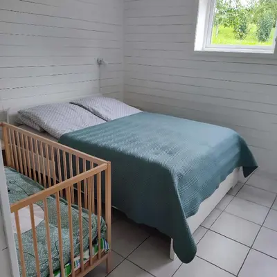 a bedroom with a bed with a crib in it at Lillehammer, Gjøvik pâ 2836 Biri apartments in Biri