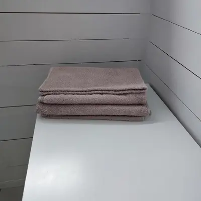 a stack of towels sitting on a shelf in a room at Lillehammer, Gjøvik pâ 2836 Biri apartments in Biri