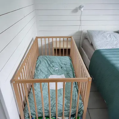 a baby crib with a teddy bear in it at Lillehammer, Gjøvik pâ 2836 Biri apartments in Biri