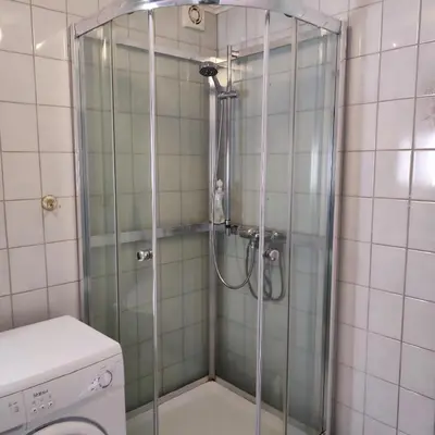 a shower with a glass door in a bathroom at Lillehammer, Gjøvik pâ 2836 Biri apartments in Biri