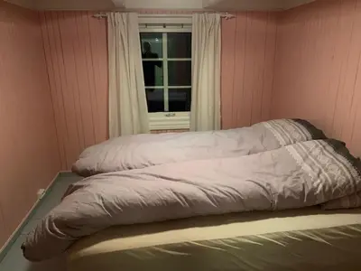 a bed sitting in a room with a window at Rikstaddal in Kalvhagen