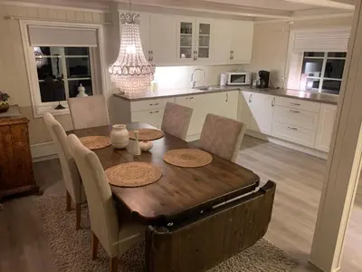 a kitchen with a wooden table with chairs and a dining room at Rikstaddal in Kalvhagen