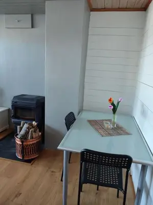 a table and a chair with a vase of flowers on it at Biri nær Gjøvik ,Hamar og Lillehammer apartments in Gjøvik