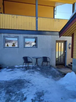 two chairs and a table in front of a building at Biri nær Gjøvik ,Hamar og Lillehammer apartments in Gjøvik