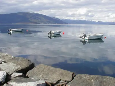 two boats sitting in the water on a lake at Fjordhytte-3 in traumhafter Lage 100 Meter vom Hardangerfjord, Motorboot mietbar in Ænes