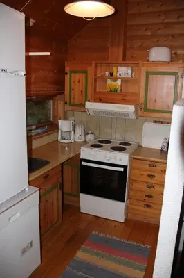 a kitchen with a white stove and wooden cabinets at Fjordhytte-40 im Vestland - Hordaland nahe Rosendal in Rosendal