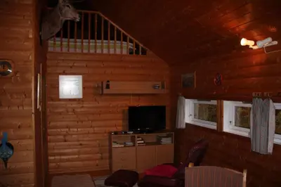 a living room with a tv in a log cabin at Fjordhytte-40 im Vestland - Hordaland nahe Rosendal in Rosendal