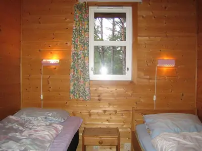 two beds in a log cabin with a window at Fjordhytte-38 bei Rosendal am Hardangerfjord in Rosendal