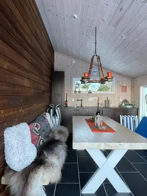 a dining room with a table and two dogs at Fjordhytte-13 in Ænes