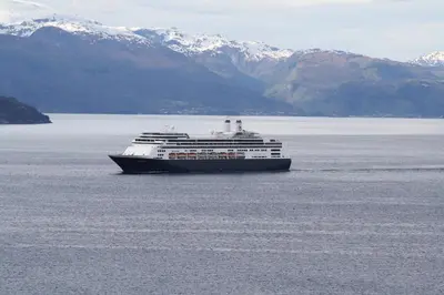 a cruise ship in a large body of water with mountains at Fjordhytte-13 in Ænes