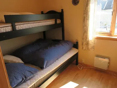 two bunk beds in a room with a window at Fjordhytte-36 in Bøvågen