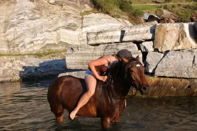 a woman riding a horse in the water at Fjordhytte-17 in Norwegen direkt am Fjord, mit mietbaren 9,9 PS bis 60 PS Motorbooten in Bjordal