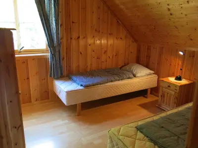 a room with a bed in a wooden cabin at Fjordhytte-23 direkt am Sognefjord, mit mietbaren Motorbooten 9,9-60 PS in Bjordal