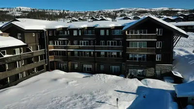 a large building in the snow with snow covered roofs at Charming Top Floor Apartment With Balcony in Beitostøl