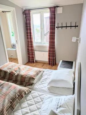 a bedroom with two beds in front of a window at Charming Top Floor Apartment With Balcony in Beitostøl