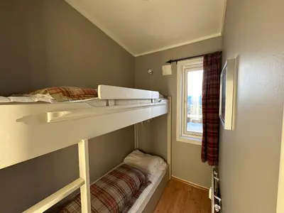 a small room with a bunk bed and a window at Charming Top Floor Apartment With Balcony in Beitostøl