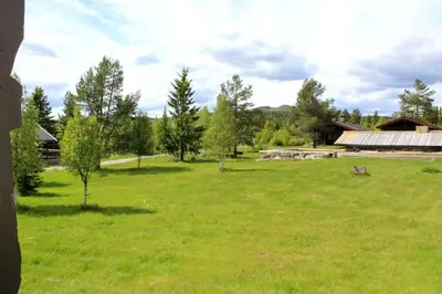 a large green field with a building and trees at Lifjellhytte 10 by Norgesbooking - cabin at Golsfjellet in Gol
