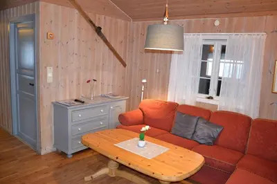 a living room with a red couch and a table at Lifjellhytte 10 by Norgesbooking - cabin at Golsfjellet in Gol