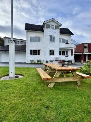 a picnic table in the grass in front of a building at Villa Utsikten Romsdalshorn in Åndalsnes