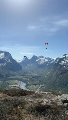two kites flying over a valley with snow covered mountains at Villa Utsikten Kirketaket in Åndalsnes