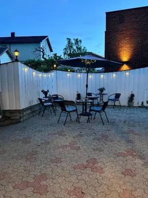 a patio with a table and chairs and an umbrella at Villa Utsikten Romsdalen in Åndalsnes