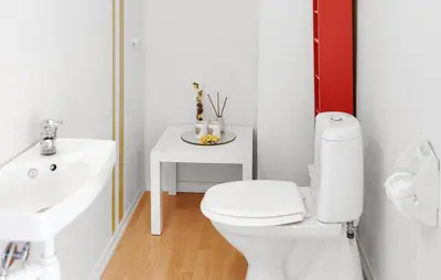 a white bathroom with a toilet and a sink at Doktorgarden in Selje