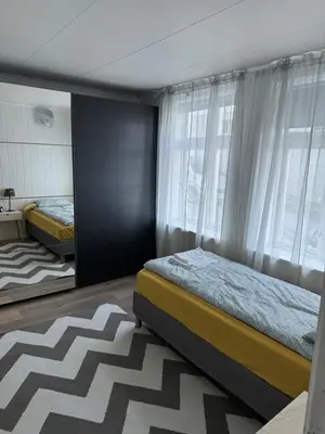 a bedroom with two beds and a large window at Duży apartament w centrum in Ålesund
