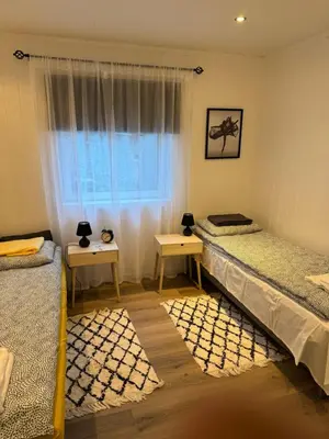two twin beds in a room with a window at Duży apartament w centrum in Ålesund