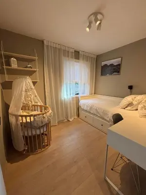 a bedroom with a bed and a crib at Utsikten in Lillehammer