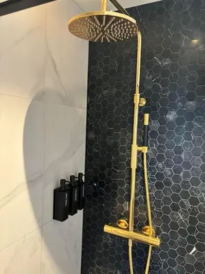 a shower in a bathroom with a black tile wall at Utsikten in Lillehammer
