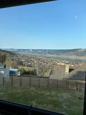 a view from a window of a yard with a fence at Utsikten in Lillehammer