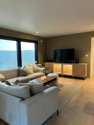 a living room with a couch and a tv at Utsikten in Lillehammer