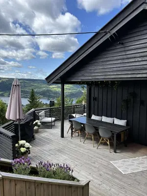 a wooden deck with a table and chairs on a house at Utsikten in Lillehammer