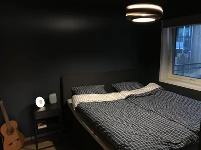 a black bedroom with a bed and a window at Pen leilighet i Trondheim in Trondheim