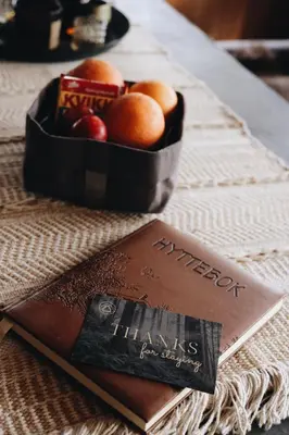 a book with a bowl of fruit on a table at Koselig fjellhytte i Trysil Ski & Turmuligheter in Trysil
