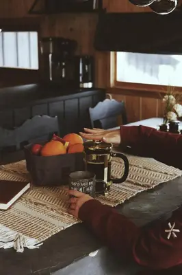 a person sitting at a table with a bowl of fruit at Koselig fjellhytte i Trysil Ski & Turmuligheter in Trysil