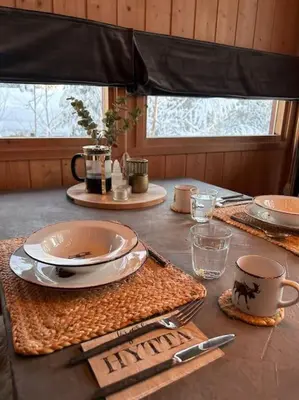 a table with plates and utensils on top of it at Koselig fjellhytte i Trysil Ski & Turmuligheter in Trysil