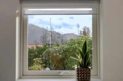 a window with a potted plant in a window sill at KS Apartment Modern & cozy flat 20 min from Bergen centre in Espeland