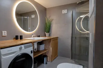 a bathroom with a washing machine and a mirror at KS Apartment Modern & cozy flat 20 min from Bergen centre in Espeland