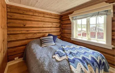 a bedroom with a bed in a log cabin at Beautiful Home In Øyer With Wifi in Øyer
