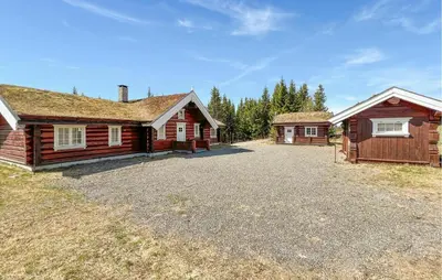 an empty driveway in front of two log homes at Beautiful Home In Øyer With Wifi in Øyer