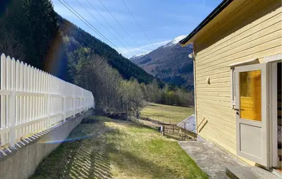 a fence next to a house with a view of a mountain at 4 Bedroom Gorgeous Home In Valldal in Valldal