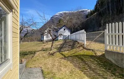 a white fence and a white house with a mountain at 4 Bedroom Gorgeous Home In Valldal in Valldal