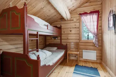 a bedroom with a bunk bed in a log cabin at Trysilfjell sør 825 in Trysil